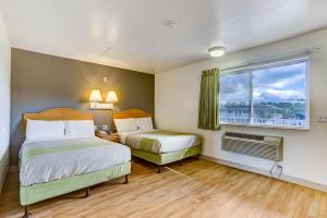 a hotel room with two beds and a window at Studio 6 Extended Stay - Kissimmee, FL - Orlando in Orlando +20 photos