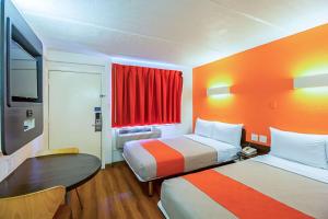 a hotel room with two beds and a table and a tv at Ocean Inn South Padre Island in South Padre Island +18 photos