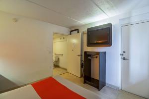 Cette chambre dispose d'une salle de bains avec une télévision murale. dans l'établissement Ocean Inn South Padre Island, à South Padre Island