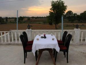 a table with a white table cloth on it with chairs at Prem Home Stay in Khajurāho