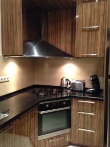 a kitchen with a stove top oven and wooden cabinets at 11 Shio Chitadze St in Tbilisi City