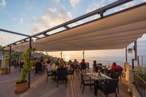 een groep mensen die aan een tafel op een patio zitten bij Hostal Sa Baronia in Banyalbufar