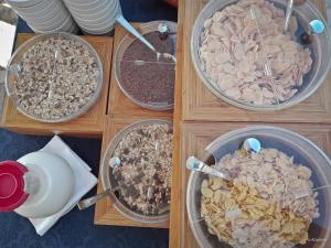 three bowls of granola and other food items on a table at Hotel Eden in San Domino