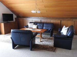 ein Wohnzimmer mit Sofas, einem Tisch und Stühlen in der Unterkunft Ferienwohnung Schleibinger in Laufenburg