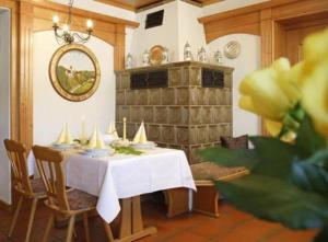 a dining room with a white table and a fireplace at Hotel Landgasthof Gschwendtner in Allershausen