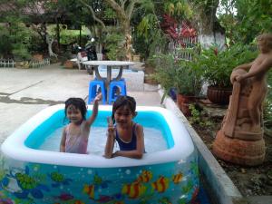 two children in an inflatable pool in a backyard at Nam Thanh Homestay in Vĩnh Long