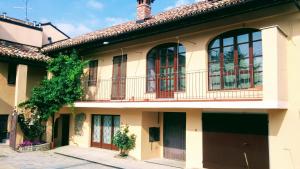 an old house with a balcony on a street at La Vigna del Parroco-2- in Serralunga d'Alba