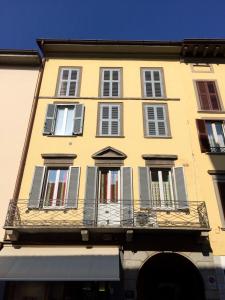 ein gelbes Gebäude mit Fenstern und einem Balkon in der Unterkunft Al Centro Città in Bergamo