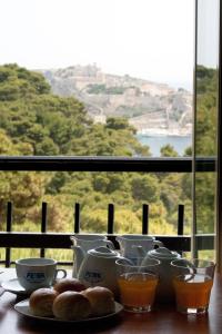 a table with plates of food and cups and a window at Hotel Eden in San Domino