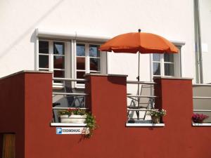 un paraguas naranja sentado en un lateral de un edificio en Ferienwohnung Berweiler, en Schweich