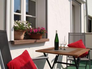 una mesa y sillas con una botella de vino en el patio en Ferienwohnung Berweiler, en Schweich