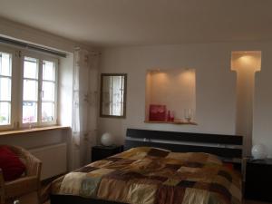 1 dormitorio con 1 cama, 1 silla y ventanas en Ferienwohnung Berweiler, en Schweich