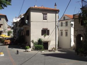 un bâtiment blanc avec une fenêtre sur une rue dans l'établissement Apartments Dobrinj, à Dobrinj