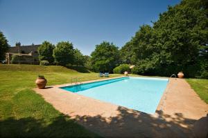 a swimming pool in a yard next to a field at La Spinetta in San Lorenzo Nuovo