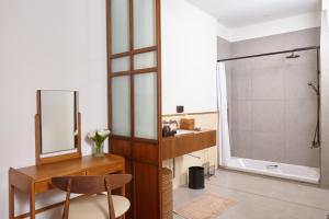 a bathroom with a vanity and a shower with a mirror at Chann Bangkok Noi in Bangkok