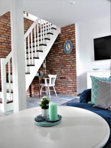a living room with a white table and a brick wall at Apartament Konopnickiej in Świnoujście