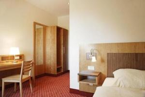 a hotel room with a bed and a desk and a chair at Hotel Landgasthof Gschwendtner in Allershausen