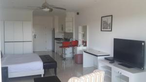 a living room with a bed and a flat screen tv at View Talay 6 Pattaya in Pattaya
