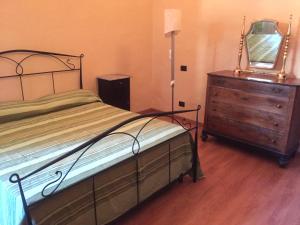 ein Schlafzimmer mit einem Bett und eine Kommode mit einem Spiegel in der Unterkunft Palazzo di Città in Saluzzo