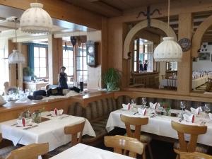 a dining room with two tables and a mirror at Gasthof Hirschen in Sibratsgfäll