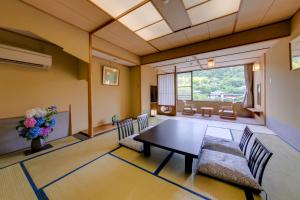 sala de estar con mesa y sillas en Komatsuya Hachinobou, en Izunokuni