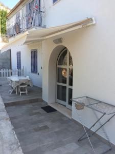 a patio with a table and a balcony at Casetta Lavanda in Pomonte