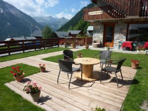 a wooden deck with chairs and a table in a yard at Les Glières - Champagny-en-Vanoise in Champagny-en-Vanoise