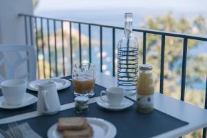 a table with plates of food and a bottle on a balcony at Villa Crawford in San Nicola Arcella