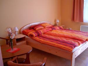 een slaapkamer met een bed en een tafel met een stoel bij Cserkeszőlőszállások-Hőforrásszállások in Cserkeszőlő
