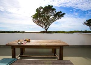 a wooden table on a patio with a tree in the background at Le Pilleur d'Epaves in Cléden-Cap-Sizun +9 photos