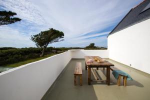 a table on the balcony of a house at Le Pilleur d'Epaves in Cléden-Cap-Sizun