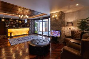 a living room with a couch and a tv and a fireplace at Centurion Hotel & Spa Kurashiki Station in Kurashiki