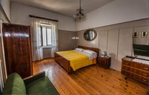 ein Schlafzimmer mit einem Bett und einem Sofa darin in der Unterkunft Casa Alice in Malosco