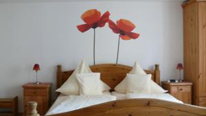 a bedroom with a bed with flowers on the wall at Hotel Andreasstuben in Weißenburg in Bayern