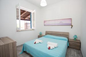 1 dormitorio con 1 cama con 2 almohadas de animales en Titina Village Porto, en Vulcano