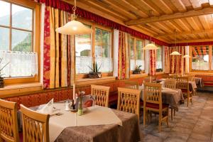 ein Restaurant mit Tischen, Stühlen und Fenstern in der Unterkunft Landgasthof Seisenbergklamm in Weissbach bei Lofer