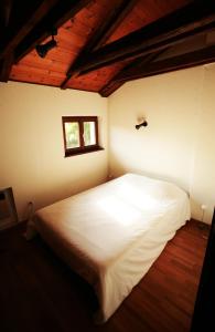 una camera con un letto bianco e una finestra di Cozy apartment in the green a Locarno