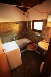 een badkamer met een bad, een toilet en een wastafel bij Cozy apartment in the green in Locarno