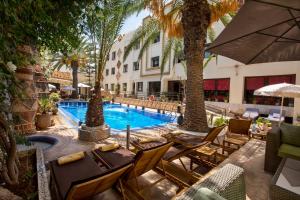 an outdoor patio with chairs and a swimming pool at Atlantic Hotel Agadir in Agadir