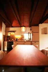 a kitchen with a wooden table with chairs in it at Cozy apartment in the green in Locarno