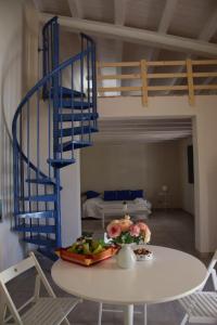 a room with a table and a blue spiral staircase at Tempo Di Vendicari in La Banca