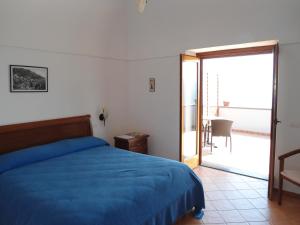 ポジターノにあるLe Ghiandeのベッドルーム1室(ベッド1台付)、バルコニーへのドアが備わります。