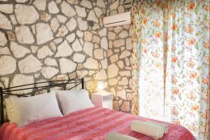 ラガナスにあるHarmony Villasの石壁のベッドルーム1室(ベッド1台付)