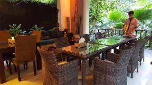 a man sitting at a dining room table with chairs at Villa Purnamasari in Ubud