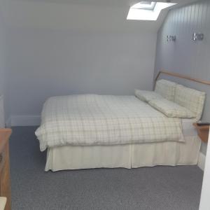 a bedroom with a bed with two pillows on it at Glenholme Apartments in Tenby