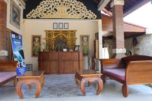 a living room with wooden furniture and a chandelier at Mans Cottages & Spa in Pemuteran