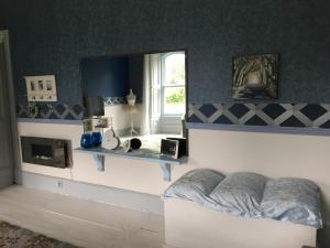 a living room with a couch and a mirror at Gardenvale Manor House B&B in Stranocum