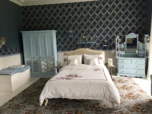 sypialnia z łóżkiem i niebieską ścianą w obiekcie Gardenvale Manor House B&B w mieście Stranocum