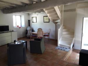 ein Wohnzimmer mit einer Treppe, einem Tisch und Stühlen in der Unterkunft Maison De Charme in Cellettes