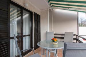 una mesa y sillas en una habitación con balcón en Nada, en Fažana